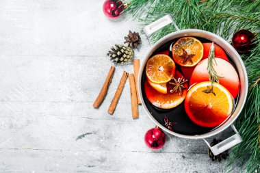 Noel sıcak Mulled şarap baharat ve otlar bir tencerede. Rustik bir arka plan üzerinde.