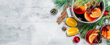 Noel sıcak Mulled şarap baharat ve otlar bir tencerede. Rustik bir arka plan üzerinde.