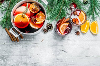 Noel sıcak Mulled şarap baharat ve otlar bir tencerede. Rustik bir arka plan üzerinde.