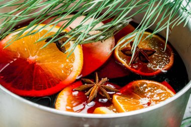 Baharat ve baharat ile bir tencerede mulled şarap. Ahşap bir arka plan üzerinde.