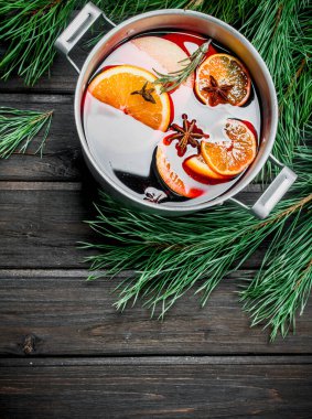 Çam dalları mulled şarap. Ahşap bir arka plan üzerinde.