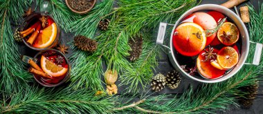 Çam dalları ve koniler mulled şarap. Rustik siyah arka plan üzerine.