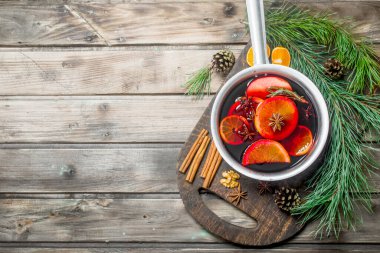 Baharat pot mulled şarap. Ahşap bir arka plan üzerinde.