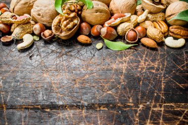 Fındık arka plan. Fındık yeşil yaprakları ile farklı tür. Ahşap bir arka plan üzerinde.