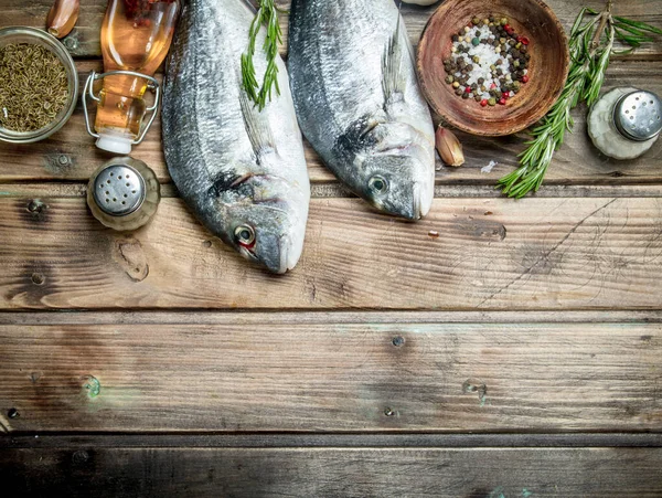 Çiğ deniz balığı aromatik otlar ve baharatlar ile. Ahşap bir arka plan üzerinde