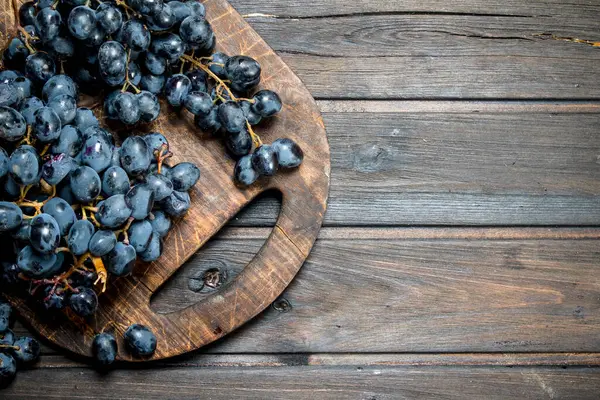 stock image Ripe black grapes. On a wooden background.