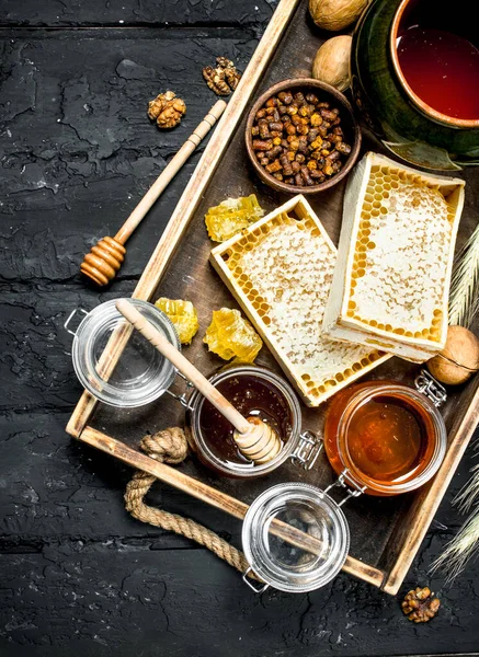 Tatlım ahşap tepsi üzerinde farklı türde. Siyah bir rustik arka planda.