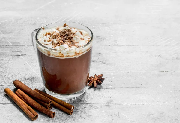 Sıcak çikolata şekerleme ve tarçın ile. Rustik bir arka plan üzerinde.
