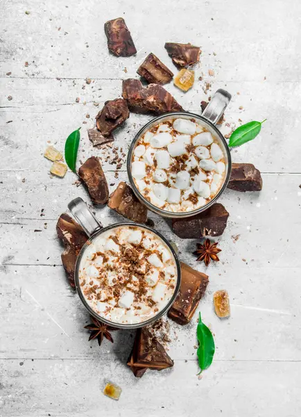 Sıcak çikolata bitter çikolata ve şekerleme parçaları ile. Rustik bir arka plan üzerinde.