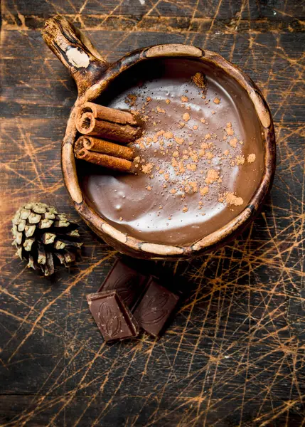 Sıcak çikolata tarçın ile sopa. Ahşap bir arka plan üzerinde.