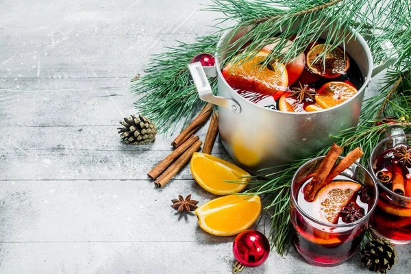 Noel sıcak Mulled şarap baharat ve otlar bir tencerede. Rustik bir arka plan üzerinde.