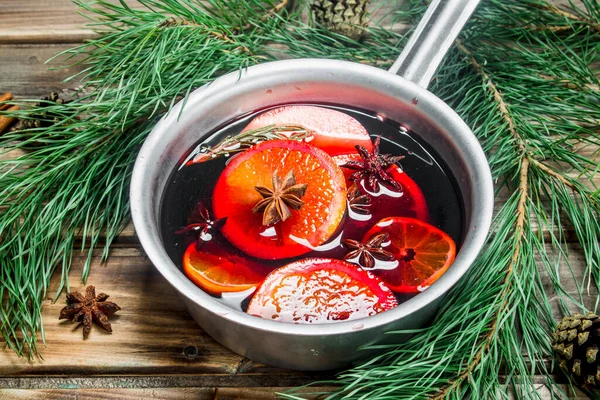 Baharat pot mulled şarap. Ahşap bir arka plan üzerinde.