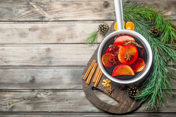 Baharat pot mulled şarap. Ahşap bir arka plan üzerinde.