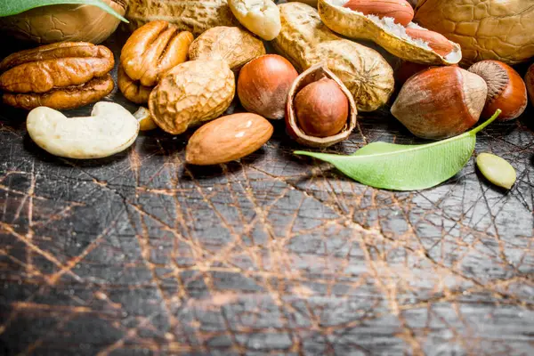 Fındık arka plan. Fındık yeşil yaprakları ile farklı tür. Ahşap bir arka plan üzerinde.