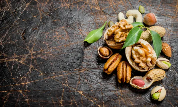 Fındık arka plan. Yeşil yaprakları ile farklı fındık ürün yelpazesine. Ahşap bir arka plan üzerinde.