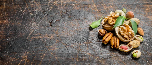 Fındık arka plan. Yeşil yaprakları ile farklı fındık ürün yelpazesine. Ahşap bir arka plan üzerinde.