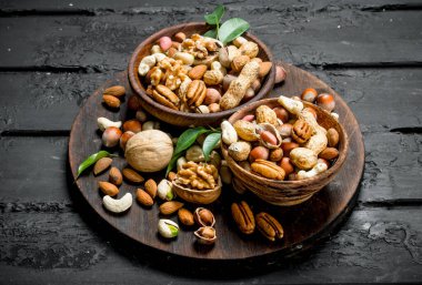 Kase fındık farklı türde ürün yelpazesine. Rustik siyah arka plan üzerine.