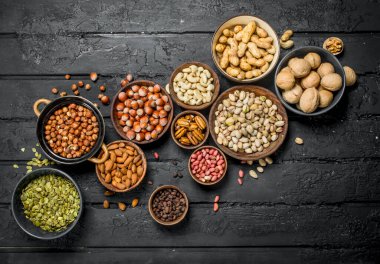 Kase içinde farklı fındık ürün yelpazesine. Rustik siyah arka plan üzerine.