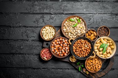 Kase içinde farklı fındık ürün yelpazesine. Rustik siyah arka plan üzerine.