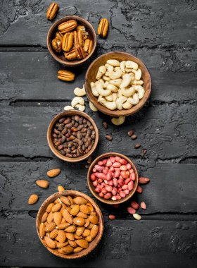 Kase içinde farklı fındık ürün yelpazesine. Rustik siyah arka plan üzerine.