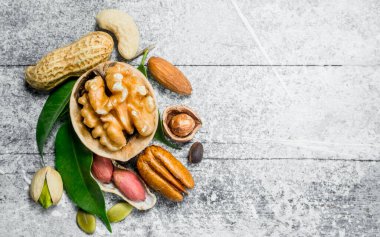 Yeşil yaprakları ile çeşitli fındık. Rustik bir arka plan üzerinde.