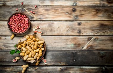 Kabuklu fıstık ve kaseler soyulmuş. Ahşap bir arka plan üzerinde.