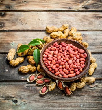 Kabuklu fıstık bir kase. Ahşap bir arka plan üzerinde.