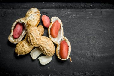 Kabuklu yer fıstığı. Siyah rustik arka plan üzerinde.