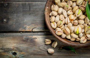 Antep fıstığı kabın içinde. Ahşap bir arka plan üzerinde.