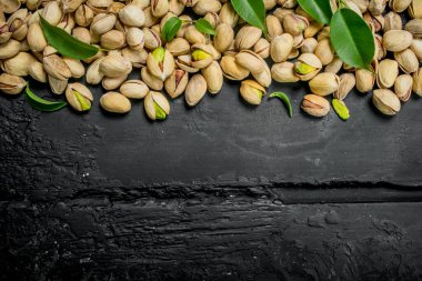 Yaprakları ile Antep fıstığı. Rustik siyah arka plan üzerine.