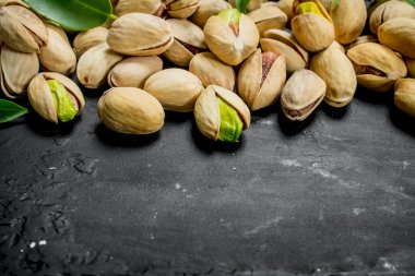 Yaprakları ile Antep fıstığı. Rustik siyah arka plan üzerine.