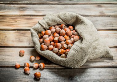 Fındık çantada. Ahşap bir arka plan üzerinde.