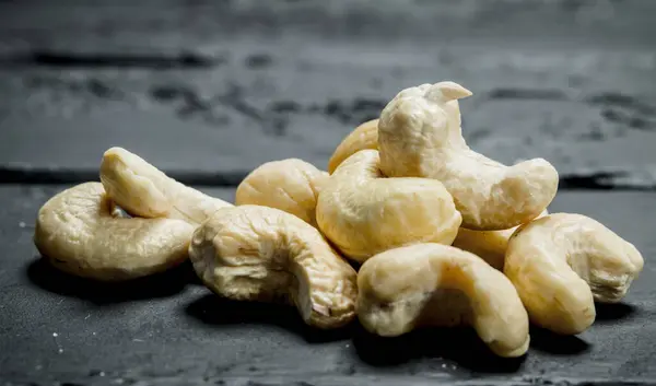 stock image Cashew nuts . On a black rustic background.