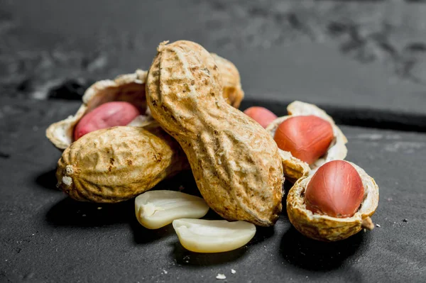 Des Cacahuètes Avec Des Coquilles Sur Fond Rustique Noir — Photo