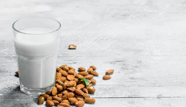 Badem sütü bir cam. Rustik bir arka plan üzerinde.