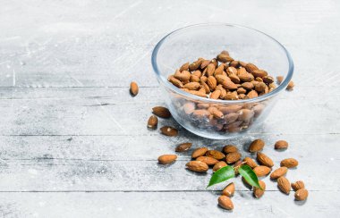 Badem yaprakları ile bir cam kabın içinde. Rustik bir arka plan üzerinde.