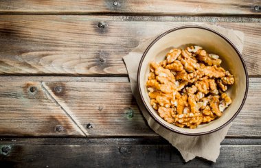 Kabuklu ceviz bir kase. Ahşap bir arka plan üzerinde.