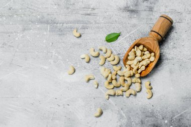 Kaju fıstığı ahşap Kepçe. Rustik bir arka plan üzerinde.