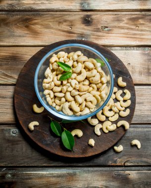 Bir kase içinde kaju fıstığı. Ahşap bir arka plan üzerinde.