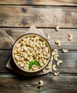 Bir kase içinde kaju fıstığı. Ahşap bir arka plan üzerinde.