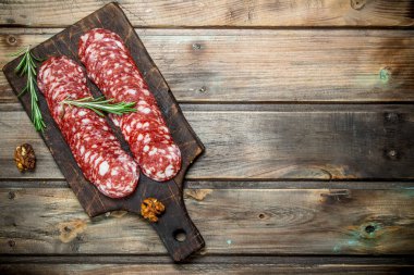 Biberiye ve ceviz ile dilimlenmiş salam. Ahşap bir arka plan üzerinde.