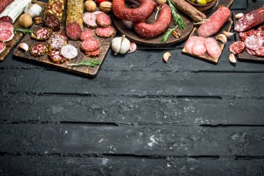 Salam ahşap tahta üzerinde farklı türleri. Rustik siyah arka plan üzerine.