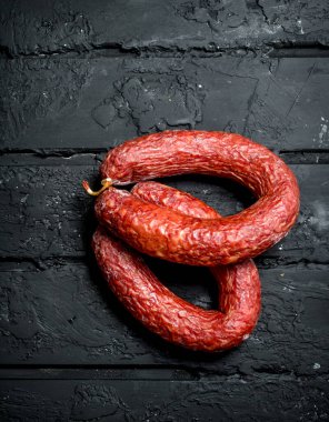 Salam baharat ve otlar ile füme. Rustik siyah arka plan üzerine.