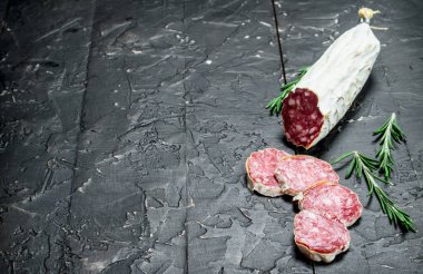 Salam kokulu rosemary ile. Rustik siyah arka plan üzerine.