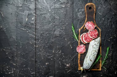 Salam kokulu rosemary ile. Rustik siyah arka plan üzerine.