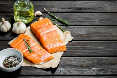 Çiğ somon fileto sarımsak ve otlar ile balık. Ahşap bir arka plan üzerinde.