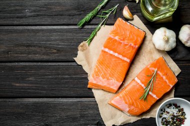 Çiğ somon fileto sarımsak ve otlar ile balık. Ahşap bir arka plan üzerinde.