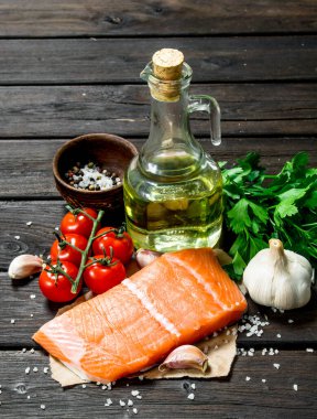 Çiğ somon balık biftek sarımsak ve domates ile. Ahşap bir arka plan üzerinde.