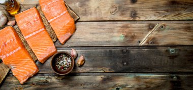 Baharat ve zeytinyağı ile çiğ somon balık biftek. Ahşap bir arka plan üzerinde.