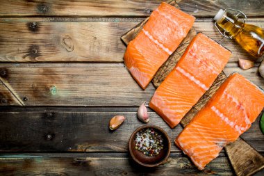 Baharat ve zeytinyağı ile çiğ somon balık biftek. Ahşap bir arka plan üzerinde.